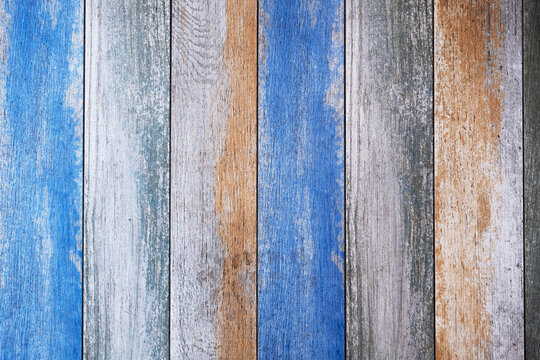 wooden board with bright blue and beige paint and cracks. vertical lines. rough surface texture