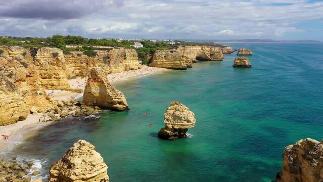 Praia da Marinha, beautiful beach Marinha in Algarve, Portugal. Navy Beach (Praia da Marinha) with flying seagulls over the beach, located on the Atlantic coast in Lagoa Municipality, Algarve.