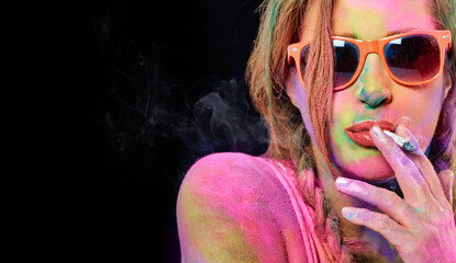 Beautiful woman covered in rainbow colored powder smoking weed cigarette