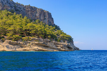 Fototapeta premium View of the rocky shore from the sea. Mediterranean Sea in Turkey. Popular tourist places. Background