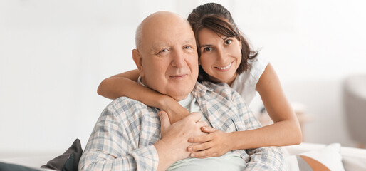 Happy elderly man with his daughter at home