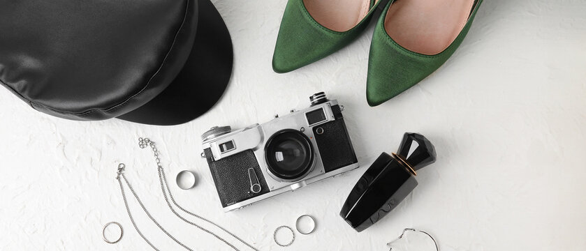 Set of female accessories with vintage photo camera on light background