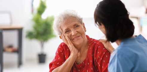 Young nurse visiting elderly woman at home