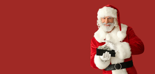 Santa Claus with money in wallet on red background with space for text