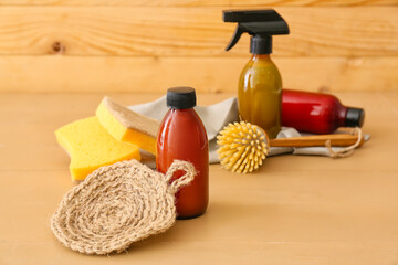 Set of natural cleaning supplies on color wooden table, closeup
