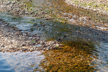 Corriente de agua que corre entre las piedras. Agua corriendo entre cantos rodados.
