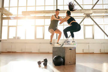 athletic couple in sportswear at training in the fitness room, woman and man together at fitness training jump