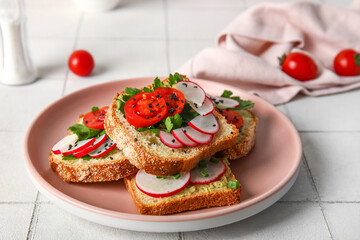 Plate with delicious radish bruschettas on white tiled table