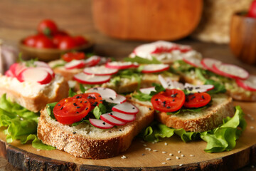 Board with delicious radish bruschettas on wooden table