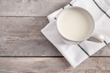 Cup of milk on wooden background