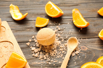 Bath bombs with orange slices and sea salt on wooden background
