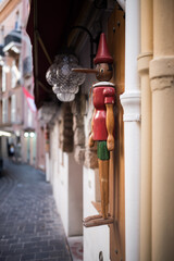 Pinocchio wooden doll in a medieval street. - obrazy, fototapety, plakaty