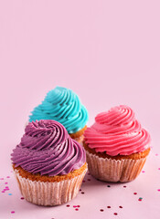 Tasty colorful cupcakes on purple background