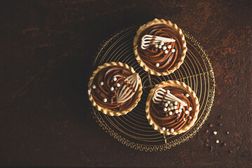 Chocolate cupcakes with whipped cream and chocolate sprinkles on vintage background