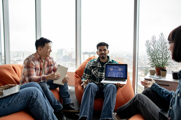 Close up of arabian male keeping portable computer while multiethnic team members taking seats on...