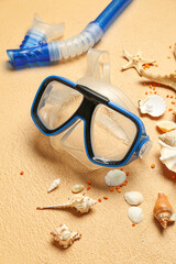 Snorkeling mask with tube, seashells and starfishes on pale orange background