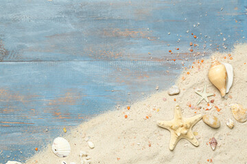 Fototapeta na wymiar Sand with starfishes and seashells on blue wooden background