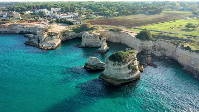 Stunning seascape with cliffs rocky arch and stacks (Faraglioni) at Torre Sant Andrea, Salento coast, Puglia region, Italy. Beautiful cliffs and sea stacks of Sant'Andrea, Salento, Apulia, Italy