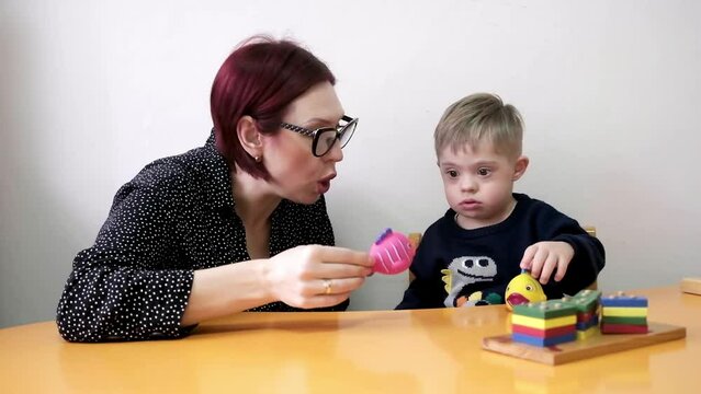 cute child living with Down syndrome and developmental disabilities included in education programs with teacher developed. rehab games for mental and physical health. 