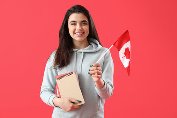 Young woman with flag of Canada and books on red background