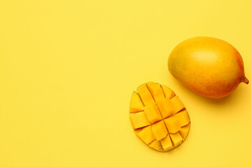Fresh ripe mangoes on yellow background