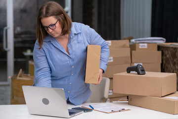 female entrepreneurs managing receipts and online orders for SMEs holding cardboard box looking to...