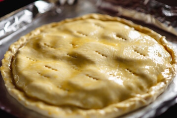 making a closed pie. Round raw pie on a baking sheet. Spread with chicken yolk.