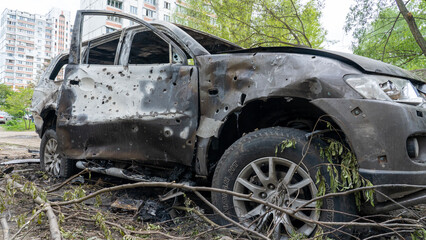 Fototapeta na wymiar Burnt car with shrapnel holes at the site of the explosion after Russia's biggest missile attack on Kiev, the concept of Russia's war against Ukraine