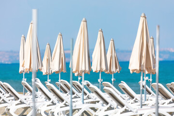 White beach umbrellas and lounge chairs . Luxury tropical beach 