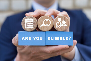 Man holding colorful blocks with inscription: ARE YOU ELIGIBLE? Concept of business, social...