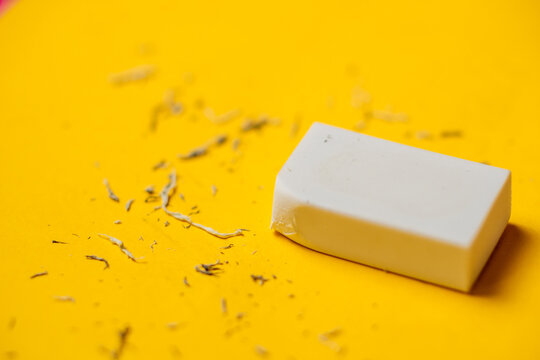 White eraser on a yellow background. Rubbish from erasure.