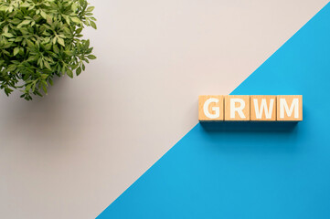 There is wood cube with the word GRWM. It is an abbreviation for Get Ready With Me as eye-catching...