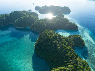 Bright morning light illuminates dramatic limestone islands that rise from West Papua's beautiful seascape. This remote part of Indonesia is known for its incredible marine biodiversity.