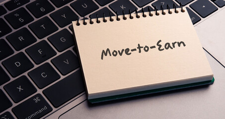 There is notebook with the word Move-to-Earn.It is an abbreviation for Move-to-Earn as eye-catching image.