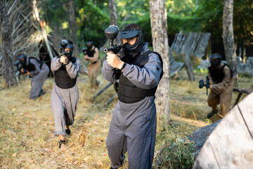 Impudent teams facing on battlefield in outdoor paintball arena during the match