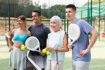 Fototapeta Portrait of four happy padel players on the tennis court outdoor obraz