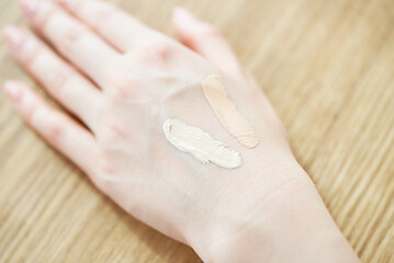 ファンデーションの色味を確かめる女性の手元