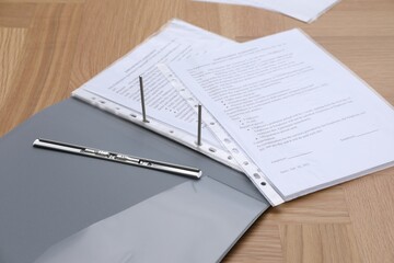 Folder with punched pockets on wooden table