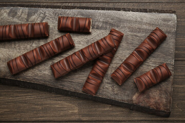 Tasty chocolate bars on wooden table, top view
