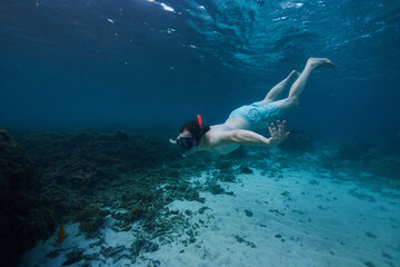 Fototapeta na wymiar man snorkeling in the ocean underwater photo