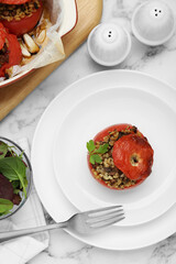 Delicious stuffed tomatoes with minced beef, bulgur and mushrooms on white marble table, flat lay