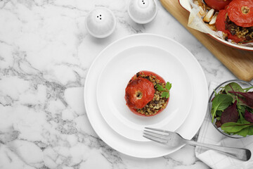 Delicious stuffed tomatoes with minced beef, bulgur and mushrooms on white marble table, flat lay. Space for text