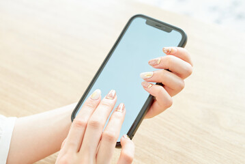 スマートフォンを操作する女性の手元