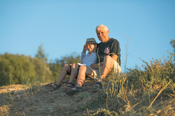 Grandfather and grandson enjoying outdoor, smiling and hugging. Concept of friendly family.