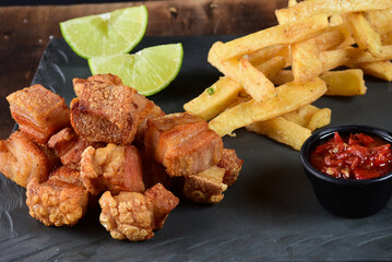 fried pork skin crackling pork pancetta pururuca typical brazilian food with lemon and french fries