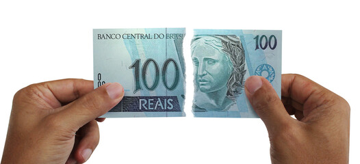 Torn money. Note of 100 reais. Currency of Brazil destroyed. Conceptual idea of ​​wasting money.
