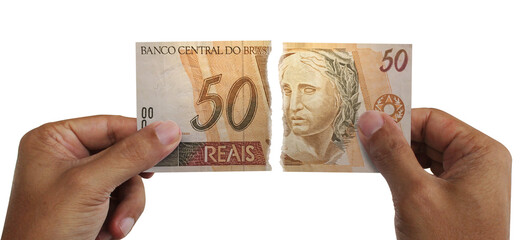 Torn money. Note of 50 reais. Currency of Brazil destroyed. Conceptual idea of ​​wasting money.