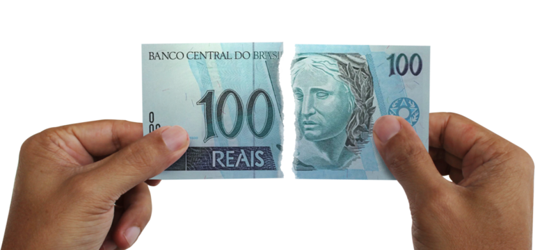 Torn money. Note of 100 reais. Currency of Brazil destroyed. Conceptual idea of ​​wasting money.
