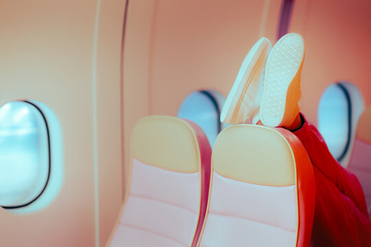 Rude Passenger Putting her Shoes on the Seat in front. Annoying tourist making the low cost flight more uncomfortable 
