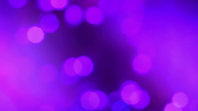 Neon purple and magenta lights and bokeh through smoke and fog. Psychedelic abstract moving background